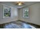 Bedroom with two windows, wood-look floors, and ceiling fan at 773 Harwell Nw Rd, Atlanta, GA 30318