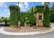 A gated community entrance with lush greenery, stone pillars, and signage at 738 Stickley Oak Way, Woodstock, GA 30189