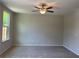 Spacious bedroom with neutral carpet, ceiling fan, and a window with natural light at 1267 Lucan Nw Ln # Wc217, Lawrenceville, GA 30043