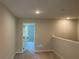 Open loft area with carpet and a view of another room, offering flexible living space at 1267 Lucan Nw Ln # Wc217, Lawrenceville, GA 30043