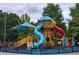 Community playground with a playset featuring colorful slides, a climbing structure, and a covered play area at 4140 Onslow Se Pl, Smyrna, GA 30080