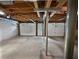 Unfinished basement with concrete floor, garage doors, utilities, and exposed beams at 3549 Meadow Chase Dr, Marietta, GA 30062