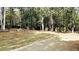 Large, fenced backyard with mature trees and a concrete patio, perfect for outdoor activities at 115 Bond Dr, Ellenwood, GA 30294