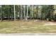 Large, fenced backyard with mature trees and a custom fire pit area at 115 Bond Dr, Ellenwood, GA 30294