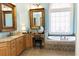 Luxurious bathroom with dual vanity sinks, a soaking tub, and a decorative window at 86 Waterford Path, Hiram, GA 30141