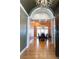 View of the dining room through an archway, showcasing its dark wood furniture and elegant chandelier at 86 Waterford Path, Hiram, GA 30141
