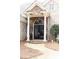 Elegant stone and brick home exterior featuring a covered front porch and ornate double front door at 86 Waterford Path, Hiram, GA 30141