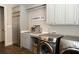 Well-equipped laundry room with modern washer, dryer, stainless steel refrigerator, and ample cabinet space at 86 Waterford Path, Hiram, GA 30141