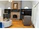 Cozy living room featuring a brick fireplace, built-in shelving, and hardwood floors at 86 Waterford Path, Hiram, GA 30141