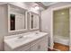 Bathroom with double sinks, white cabinets, neutral paint, and access to the shower and toilet at 3649 Peachtree Ne Rd # 201, Atlanta, GA 30319