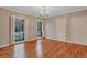 Bedroom featuring hardwood floors, neutral paint, a chandelier, and large windows with shutters at 3649 Peachtree Ne Rd # 201, Atlanta, GA 30319