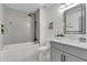 Modern bathroom featuring a tub, shower with gray tile surround, decorative floor tile, and gray vanity at 6914 Fairway Trl, Austell, GA 30168