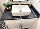 Close-up of a bathroom vanity with black countertop and modern vessel sink with gold accents at 6914 Fairway Trl, Austell, GA 30168
