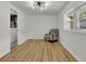 Brightly lit bedroom with white walls, hardwood floors, a ceiling fan, and a patterned armchair at 6914 Fairway Trl, Austell, GA 30168