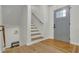 Bright foyer with hardwood floors, painted stairs, a gray front door and a modern light fixture at 6914 Fairway Trl, Austell, GA 30168