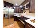 Well-lit kitchen with stainless steel appliances, white backsplash and dark wooden cabinets for a sleek design at 6914 Fairway Trl, Austell, GA 30168