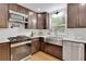 Modern kitchen with stainless steel appliances and a farmhouse sink with a large window overlooking the backyard at 6914 Fairway Trl, Austell, GA 30168