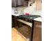 Close-up of a stainless steel stove with a glass door and stainless steel handle surrounded by dark wooden cabinets at 6914 Fairway Trl, Austell, GA 30168