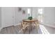 Bright dining area featuring an oval wooden table, four chairs, light-colored wood floors, and a door to the outside at 6478 Beaver Creek Trl, Atlanta, GA 30349
