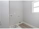 A simple laundry room with gray walls, a window, and connections for a washer and dryer at 6478 Beaver Creek Trl, Atlanta, GA 30349