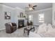 Cozy living room with a fireplace, plush chairs, ceiling fan, and contemporary decorations at 6478 Beaver Creek Trl, Atlanta, GA 30349