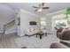 Bright living room with gray vinyl plank floors, ceiling fan and access to the dining room and kitchen at 6478 Beaver Creek Trl, Atlanta, GA 30349
