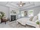 Cozy main bedroom featuring a fireplace, tray ceiling, and three windows allowing natural light to come in at 6478 Beaver Creek Trl, Atlanta, GA 30349