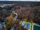 Aerial view showing property, tennis court, and the wooded surroundings in a suburban setting at 247 Huntington Ne Rd, Atlanta, GA 30309