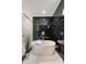 Luxurious bathroom showcasing a modern soaking tub with black marble accent wall and patterned tile flooring at 247 Huntington Ne Rd, Atlanta, GA 30309