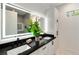 Bathroom featuring double sink vanity, light countertops, illuminated mirror, and hexagon floor tile at 247 Huntington Ne Rd, Atlanta, GA 30309