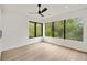 Spacious bedroom with hardwood floors, a modern ceiling fan, and large windows offering wooded views at 247 Huntington Ne Rd, Atlanta, GA 30309