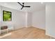 Bright, minimalist bedroom with a large window, hardwood floors, and a simple bench at 247 Huntington Ne Rd, Atlanta, GA 30309
