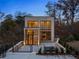 Modern home with large windows and brick accents, set against a backdrop of trees and a twilight sky at 247 Huntington Ne Rd, Atlanta, GA 30309