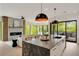 Open concept kitchen with granite island, modern lighting, and seamless flow to the living area and outdoor views at 247 Huntington Ne Rd, Atlanta, GA 30309