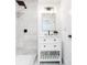 Elegant bathroom featuring a single vanity, stylish mirror, sleek shower with modern fixtures, and white tile at 5483 Wylstream, Norcross, GA 30093