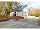 Side view of a modern home with a long driveway and black trim, complemented by lush landscaping at 5483 Wylstream, Norcross, GA 30093