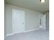 Bright bedroom featuring neutral walls, plush carpet, and a large window looking onto the home's exterior at 5380 Deer Run Dr, Conyers, GA 30094