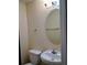 Cozy half bath features an oval mirror, vanity with sink and a toilet providing convenience for guests at 6398 Shadow Sq, Lithonia, GA 30058