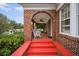 Brick porch with red steps, wicker chairs, and a porch swing at 1384 Jefferson Ave, East Point, GA 30344