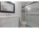 Modern bathroom with white vanity, marble-look shower, and frameless glass door at 3936 Devonshire Dr, Marietta, GA 30066