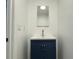 Small powder room with a navy blue vanity and a rectangular mirror at 3936 Devonshire Dr, Marietta, GA 30066