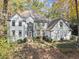 Two-story white brick house nestled in a wooded setting at 2680 Spalding Dr, Sandy Springs, GA 30350