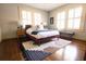 Bedroom with a plush bed, wooden floors, and white window shutters at 2791 Pearl St, East Point, GA 30344