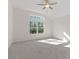 Well-lit bedroom with grey carpet, ceiling fan and large window at 212 Harvest Trl, Hiram, GA 30141