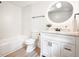 Bright bathroom featuring subway tiles, modern fixtures, and a stylish round mirror at 220 Hicks Se Dr, Marietta, GA 30060