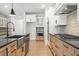 Modern kitchen with farmhouse sink, stainless steel appliances, and light wood cabinets at 2760 Marie Way, Cumming, GA 30028