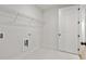 Bright laundry room with built-in shelving and tile floor at 2760 Marie Way, Cumming, GA 30028