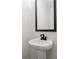 Small powder room with pedestal sink and mirror at 2760 Marie Way, Cumming, GA 30028