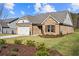 Brick house with a two-car garage and landscaped lawn at 2780 Marie Way, Cumming, GA 30028