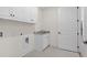 Bright laundry room with white cabinets, granite countertop, and utility sink at 2780 Marie Way, Cumming, GA 30028